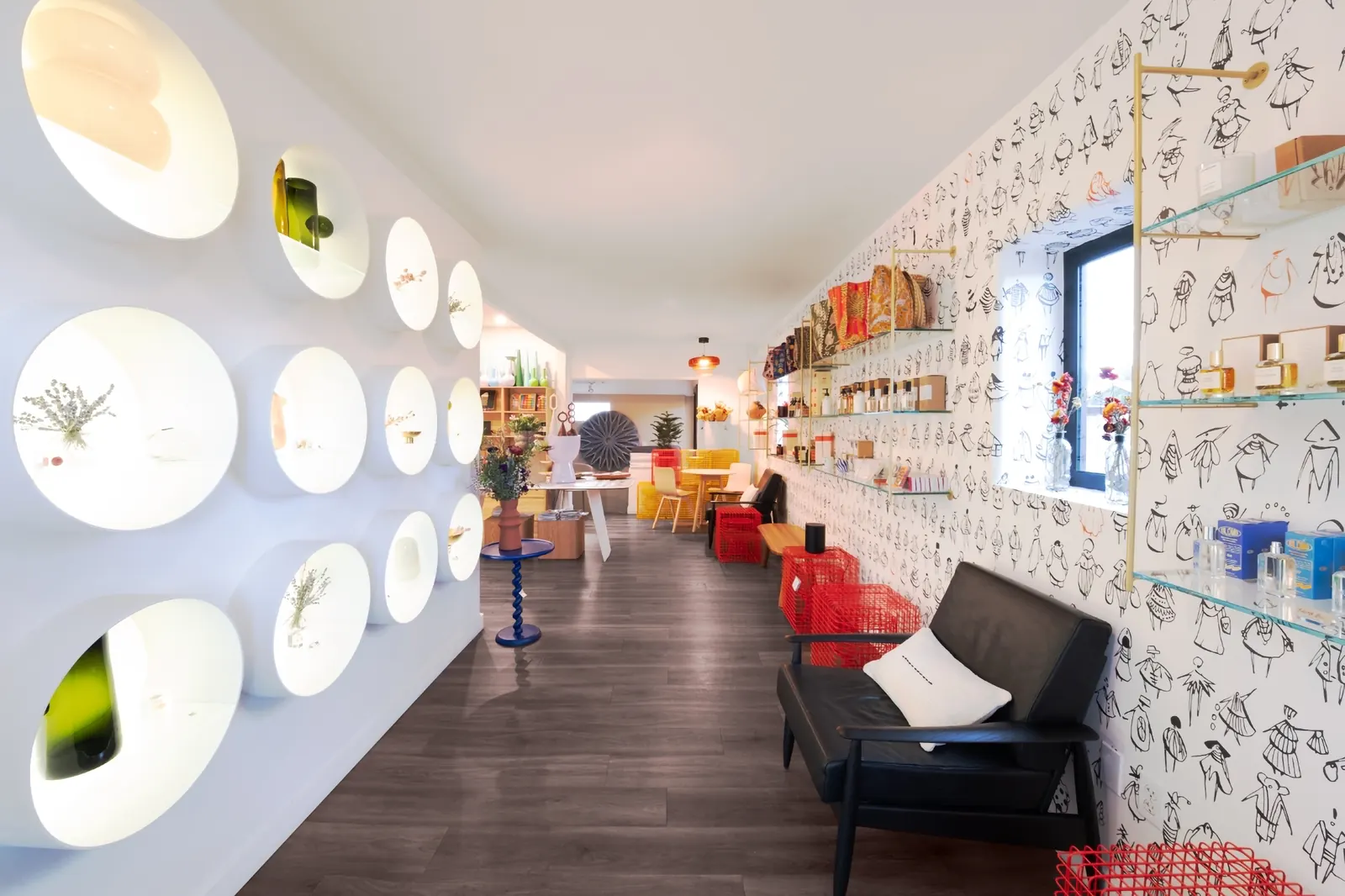 Fragrances, candles, stools and vases along the back wall of the shop.
